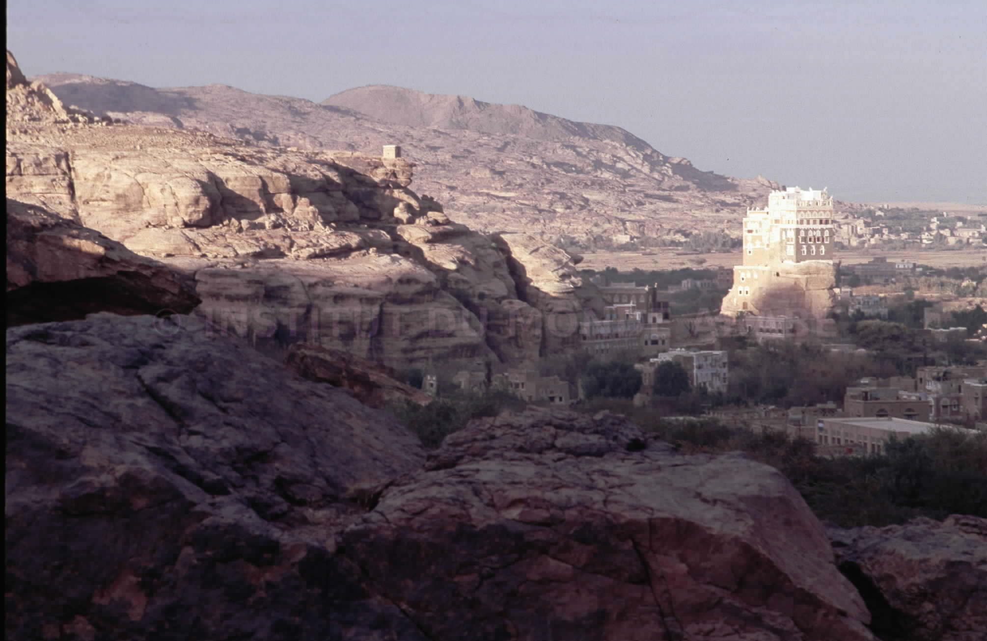 Vue sur la vallée de Wadi Dar; au sommet du piton rocheux, le palais ...